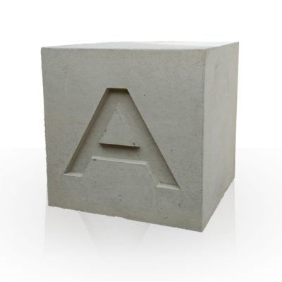 Dekoratiivne betoonist kuubik. millesse on süvistatud ehk valatud A-täht.